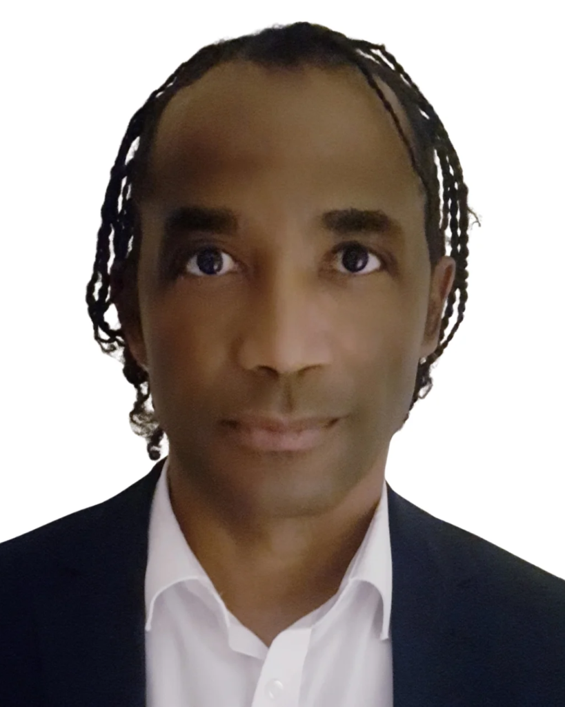 Professional headshot of a person in a white shirt and dark blazer against a white background.