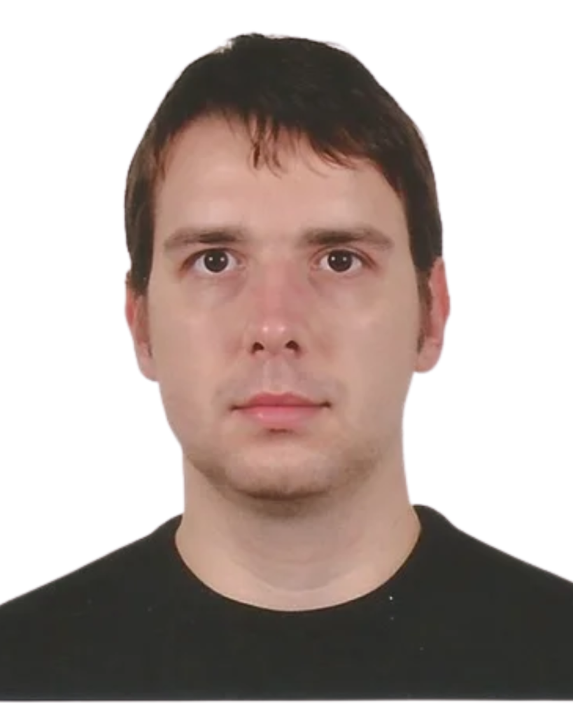 Portrait of a young man with short dark hair facing the camera, wearing a black shirt against a white background.