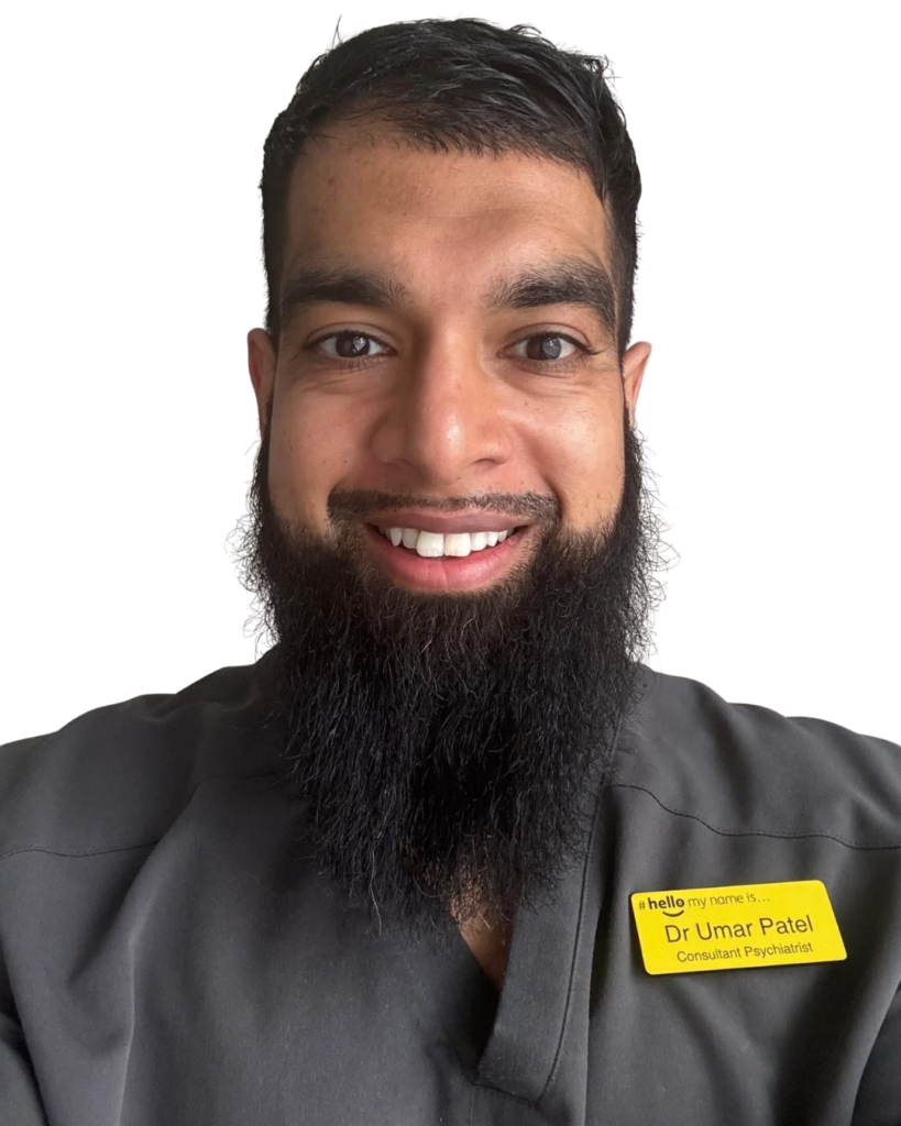 Portrait of Dr Umar Patel, a consultant psychiatrist, in a gray uniform with a yellow name badge reading 'Dr Umar Patel' on the chest.