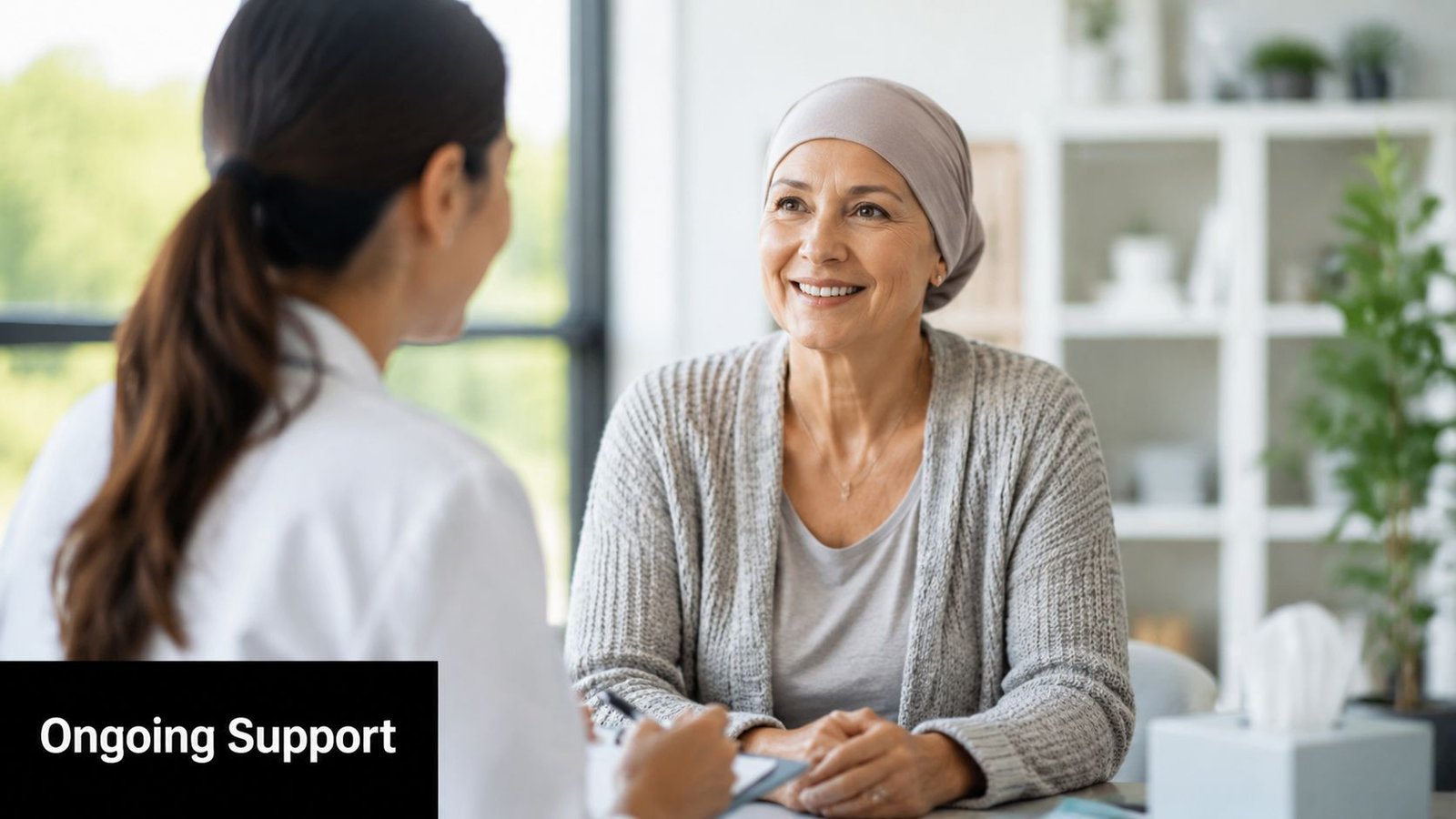A smiling woman wearing a head covering meeting with a healthcare professional for ongoing medical support.