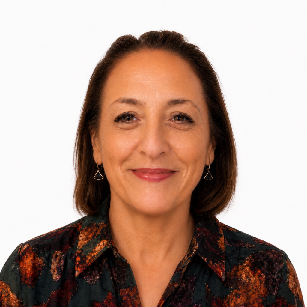 Smiling woman with short brown hair wearing a dark floral blouse, facing the camera.