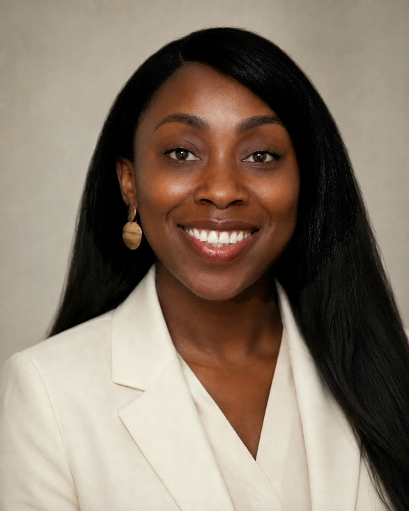 Portrait of a smiling Black woman with long black hair, wearing a beige blazer and gold earrings.